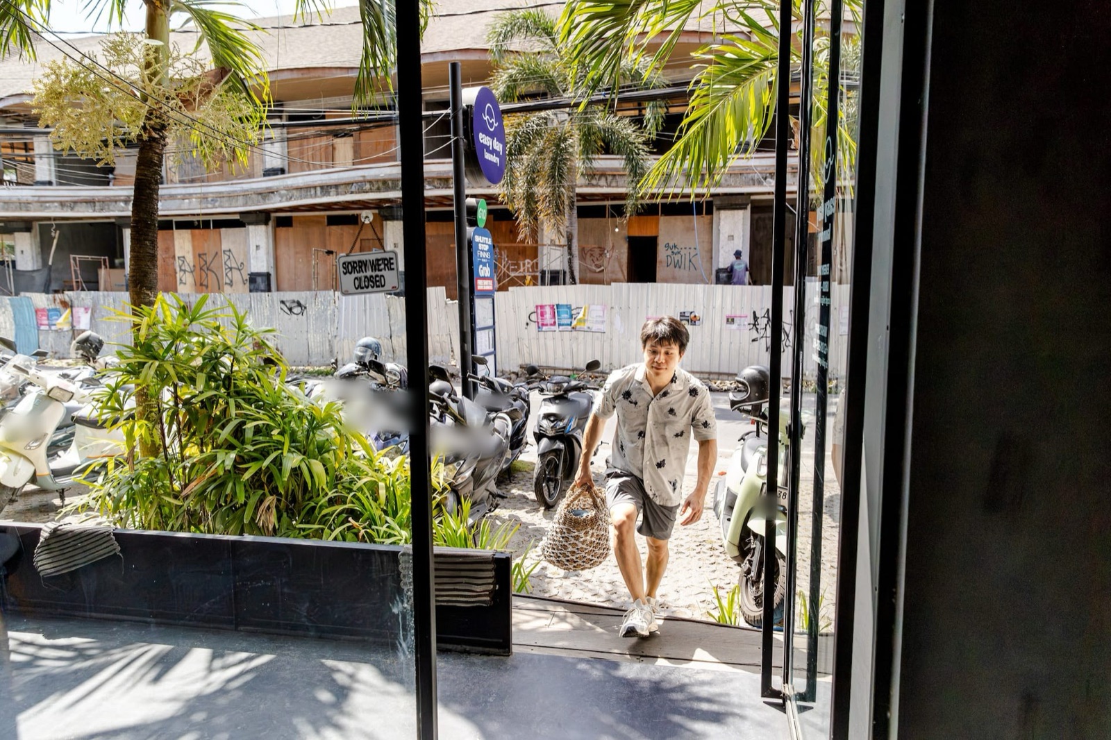 Customer walking into the Easy Day Laundry Canggu shop with a laundry basket